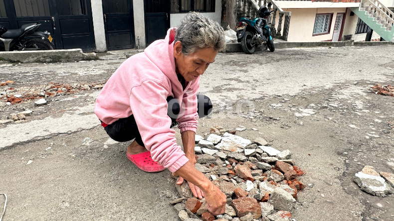 Con sus propias manos una señora en Ibagué decidió tapar los huecos de una calle Con sus propias manos una señora en Ibagué decidió tapar los huecos de una calle